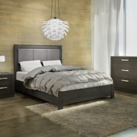 Dark bedroom with dark wooden wall, black wooden bookcases, 3 drawer dresser with a double bed with grey upholstered panel with grey duvet