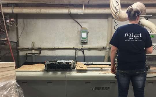 factory worker in black tshirt working with wood